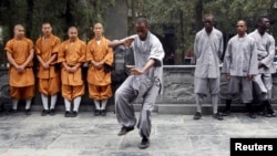 An African student (C) practices moves as other Shaolin martial arts students look on during the inauguration ceremony of a martial arts training program for African students, at the Shaolin Temple in Dengfeng, Henan province, China, Sept. 25, 2013.