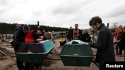Des proches de victimes pleurent au cimetière de Boutcha
