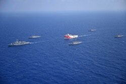 FILE - A handout photo released by the Turkish Defense Ministry Aug. 12, 2020, shows Turkish seismic research vessel Oruc Reis (C) as it is escorted by Turkish Naval ships in the Mediterranean Sea, off Antalya, Aug. 10, 2020.