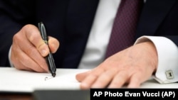 Presiden Donald Trump menandatangani instruksi presiden di Ruang Oval Gedung Putih, Senin, 20 Januari 2025, di Washington, D.C. (Evan Vucci/AP)