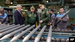 سرگی شویگو، وزیر دفاع روسیه (وسط) در حال دیدار از یک کارخانهٔ تولید تسلیحات در روسیه