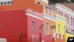 A man wearing a face mask to protect against coronavirus speaks to a woman in a building in Bo-Kaap Cape Town, South Africa, May 23, 2020.
