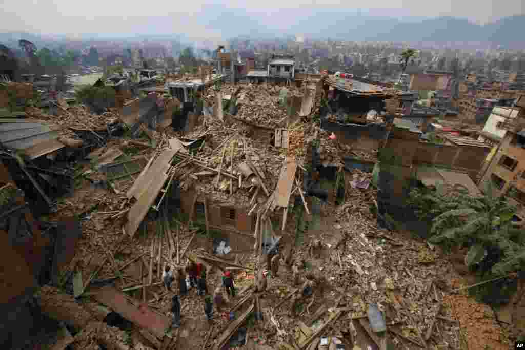 Rescue workers remove debris as they search for victims of earthquake in Bhaktapur near Kathmandu, Nepal, April 26, 2015. A massive 7.8 magnitude earthquake shook the capital and the densely populated Kathmandu Valley, causing extensive damage with toppled walls and collapsed buildings, officials said. Over 9,000 people were killed.
