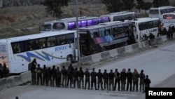 Rebel fighters pray before they are evacuated, outside Harasta in eastern Ghouta, in Damascus, Syria, March 23, 2018. 