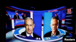 The results of the exit polls are shown on a screen at Benny Gantz's Blue and White party headquarters, following Israel's parliamentary election, in Tel Aviv, Israel, Sept. 17, 2019. 