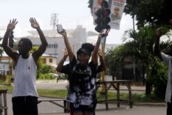FILE - People raise their hands as they approach a police checkpoint in Lagos, Nigeria, Oct. 22, 2020.