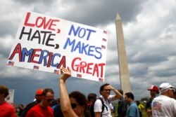 Kathleen Otal, of Arlington, Va., holds up a sign before Independence Day celebrations on the National Mall in Washington, July 4, 2019.