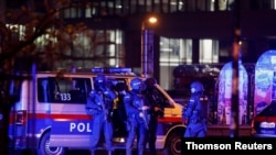 Police officers stand guard on a street after exchanges of gunfire in Vienna, November 3, 2020.