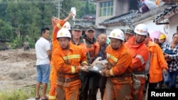 Des pompiers portent sur une civière un blessé après le séisme dans le village Gengdi, à Sichuan, Chine 8 août 2017.