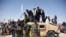 In this photo taken on June 17, 2018, Afghan Taliban militants and residents stand on a armoured Humvee vehicle of the Afghan National Army (ANA) as they celebrate a ceasefire on the third day of Eid in Maiwand district of Kandahar province.