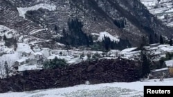 Earth from a landslide covers an area in Liangshui Village, Zhaotong City, Yunnan province, China, in this screen grab from social media video released Jan. 22, 2024. 