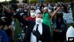 People raise their fists during a rally, June 5, 2020, in Las Vegas, against police brutality sparked by the death of George Floyd.