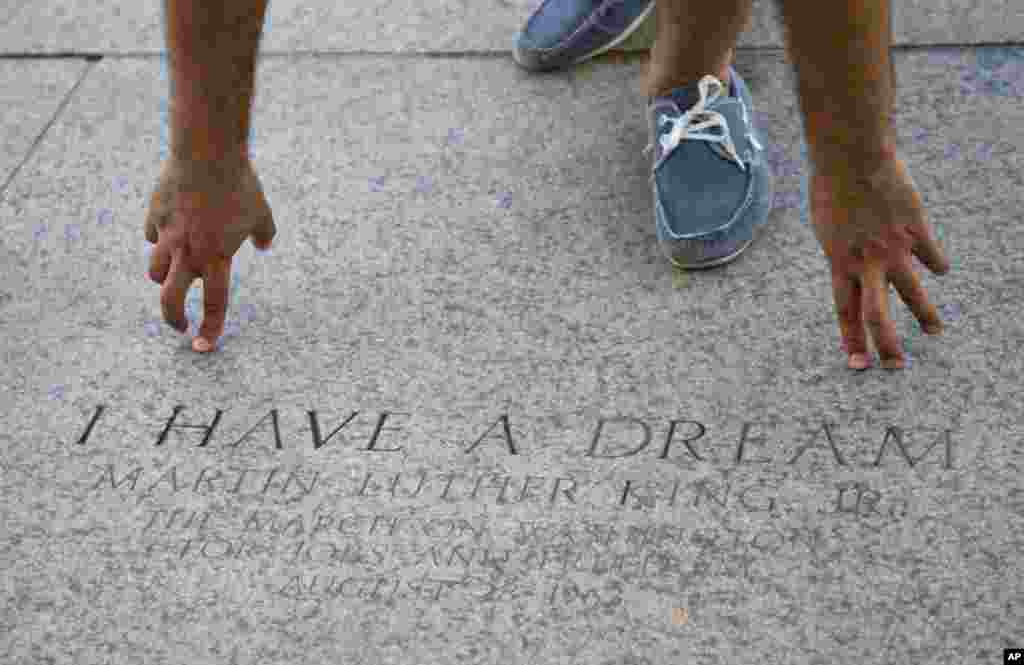 Seorang turis menunjuk pada lokasi tempat Pendeta Martin Luther King Jr. mengucapkan pidatonya yang terkenal &quot;I Have a Dream&quot; di Lincoln Memorial di Washington (22/8). (AP/Carolyn Kaster)
