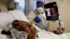 Florence Bolton, 86, a coronavirus disease (COVID-19) positive patient, lies in her intensive care bed as family members attempt to FaceTime her at Roseland Community Hospital on the South Side of Chicago, Illinois, Dec. 1, 2020. 