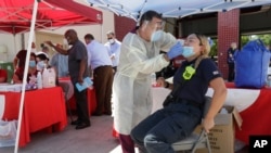 Seorang petugas pemadam kebakaran dari Dinas Pemadam Kebakaran Kota Hialeah sedang menjalani tes Covid-19 di Hialeah, Florida, 6 Agustus 2020. 