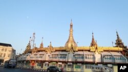 Vehicles are driven past the Sule Pagoda, Feb. 1, 2021 in Yangon, Myanmar.