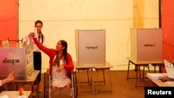 រូប​ឯកសារ៖ ស្ត្រី​ជន​ពិការ​ម្នាក់​បោះឆ្នោត​នៅ​វត្ត​មួយ​ក្នុង​ក្រុង​ភ្នំពេញ​កាល​ពី​ថ្ងៃ​ទី​២៨ ខែ​កក្កដា ឆ្នាំ​២០១៣។