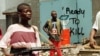 FILE - Street fighters with ULIMO-J walk past graffiti in the Liberian capital of Monrovia in this May 1996 photo.