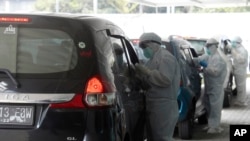 Petugas mengenakan APD, saat melakukan tes swab Covid-19 di Jakarta, Senin, 12 Oktober 2020. (AP Photo / Achmad Ibrahim)
