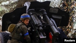 Військовослужбовець Національної гвардії України готується вести вогонь у бік російських військ на передовій у Харківській області, 21 травня 2024р. REUTERS/Valentyn Ogirenko
