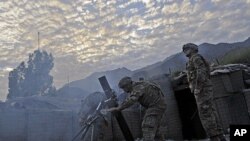 US army soldiers fire mortar rounds towards insurgent positions at Outpost Monti in Kunar province, September 17, 2011.