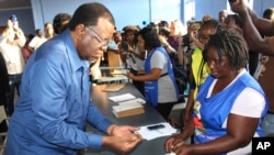 Le président namibien et chef du parti SWAPO, Hage Geingob (à g.), vote à Windhoek, en Namibie, lors des élections du pays, mercredi 27 novembre 2019.