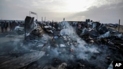 Palestinians look at the destruction after an Israeli strike where displaced people were staying in Rafah, Gaza Strip, May 27, 2024. 
