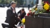 Ukraine's President Petro Poroshenko (L) and parliament speaker Volodymyr Groisman lay flowers by the photo of a police officer who was killed in violent clashes Monday, in front of Parliament in Kyiv, Ukraine, Sept. 1, 2015. 