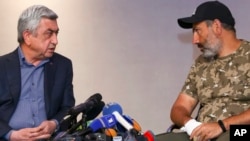 Serzh Sargsyan, left, speaks with protest leader Nikol Pashinian during their meeting in Yerevan, Armenia, April 22, 2018. (Hrant Khachatryan/PAN Photo via AP)