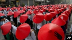 FILE - Anti-coup schoolteachers in their uniforms and traditional hats participate in a demonstration in Mandalay, Myanmar, March 3, 2021. 