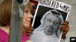 Seorang perempuan memegang poster bergambarkan wartawan Arab Saudi Jamal Khashoggi yang dibunuh di dalam konsulat Riyadh di Istanbul, Oktober lalu.