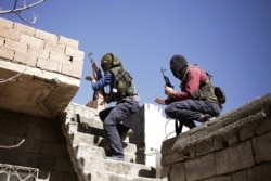 FILE - Militants from the Kurdistan Workers' Party, or PKK, run as they attack Turkish security forces in Nusaydin, Turkey, March 1, 2016.