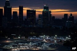 រូបឯកសារ៖ អ្នក​បើកបរ​រង់ចាំ​ចាក់​វ៉ាក់សាំង​បង្ការ​ជំងឺ​កូវីដ១៩ និង​ធ្វើ​តេស្ត​រក​ជំងឺ​នេះ​នៅ​ចំណត​រថយន្ដ​មួយ​កន្លែង​នៅ​ពហុកីឡដ្ឋាន Dodger Stadium ក្នុង​ទីក្រុង Los Angeles កាល​ពី​ថ្ងៃទី២៧ ខែមករា ឆ្នាំ២០២១។