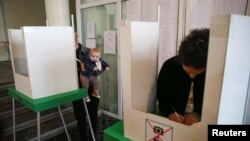 Люди голосуют во время парламентских выборов на избирательном участке в Тбилиси, Грузия, 26 октября 2024 года. REUTERS/Ираклий Геденидзе