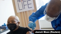  Debra Fraser-Howze receives a dose of the Pfizer-BioNTech vaccine against the coronavirus disease (COVID-19) at NYC Health + Hospitals Harlem Hospital in the Manhattan borough of New York City, New York, U.S., February 25, 2021. REUTERS/Jeenah Moon