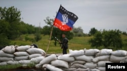 A pro-Russian activist regulates road traffic at a checkpoint outside the eastern Ukrainian city of Druzhkovka, June 2, 2014.