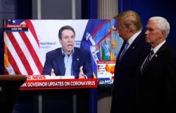 FILE - Vice President Mike Pence, right, and President Donald Trump watch a video of New York Gov. Andrew Cuomo speaking during a coronavirus task force briefing at the White House, April 19, 2020.