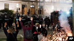 Police attempt to push back protesters outside the Kenosha County Courthouse, Aug. 24, 2020, in Kenosha, Wisconsin.