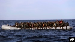 Des migrants africains dans un canot pneumatique sont secourus au large des côtes libyennes par des membres de l'ONG Proactive Open Arms, en Méditerranée, le 27 janvier 2017.