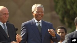 FILE - President Nelson Mandela dances at a celebration concert following his inauguration at the Union Buildings in Pretoria, South Africa, May 10, 1994.