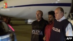 This handout picture released by the Italian police (Polizia di Stato), on June 8, 2016 shows Medhanie Yehdego Mered, 35, an Eritrean suspected of controlling a migrant trafficking network, escorted by policemen upon his extradition from Sudan to Italy late on June 6, 2016.