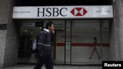 FILE - A man walks past a HSBC branch in Mexico City.