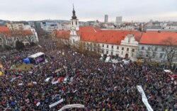 People gather at Slovak National Uprising square for a rally against corruption and to pay tribute to murdered Slovak journalist Jan Kuciak and his fiancee, Martina Kusnirova, March 9, 2018, in Bratislava, Slovakia.