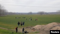 A group of migrants walk through the Turkish-Greek border in a village near Edirne, Turkey, Feb. 28, 2020. 