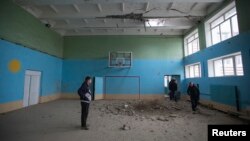 School coach Yuriy Balabanov meets his students inside a gym which was damaged by a recent shelling in Donetsk, eastern Ukraine, Oct. 19, 2014. 
