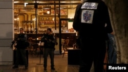Israeli policemen secure the entrance to a restaurant following a shooting attack in the center of Tel Aviv, June 8, 2016. 
