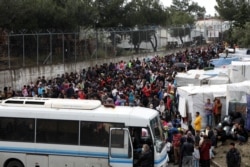 Migrants from the Moria camp wait to board busses to the port from where they will be transferred to the mainland as a precaution against the spread of the coronavirus disease (COVID-19) outbreak, on the island of Lesbos, Greece, May 3, 2020.
