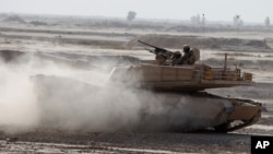 FILE - Iraqi army soldiers in a M1A1 Abrams tank, purchased from the U.S., participate in joint training with U.S. troops at the Besmaya Combat Training Center southeast of Baghdad, Iraq, Aug 24, 2010.