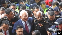 Mantan Perdana Menteri Malaysia Najib Razak (tengah), tiba di gedung pengadilan di Kuala Lumpur, Malaysia, 4 Juli 2018.