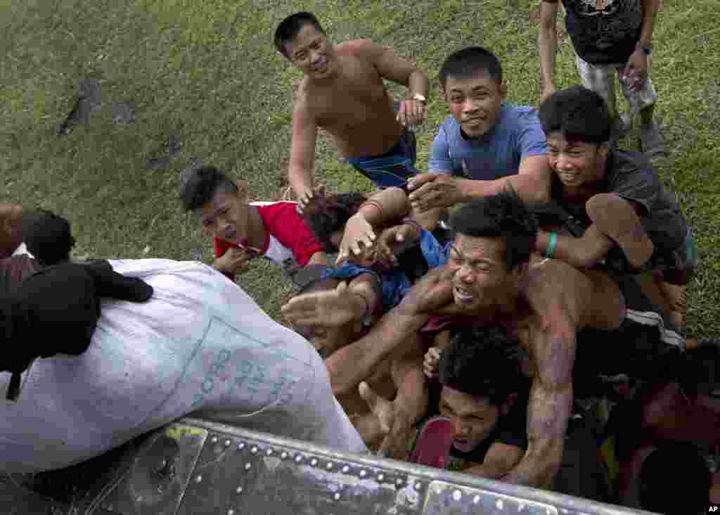 Villagers scramble for aid from a U.S. Navy helicopter in the coastal town of Tanawan, Philippines, Nov. 17. 2013.